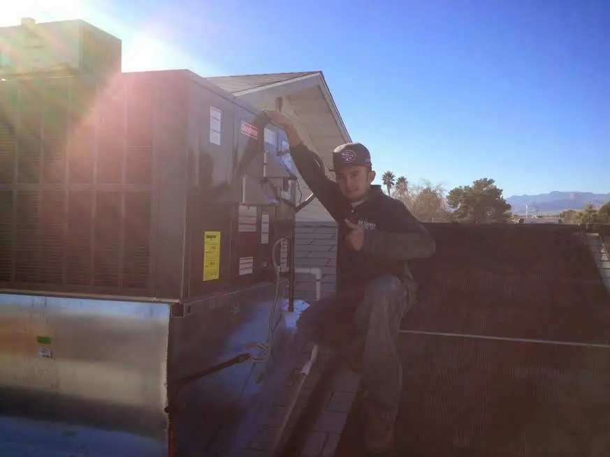 HVAC technician performing Air Duct Cleaning on a rooftop unit in Faribault